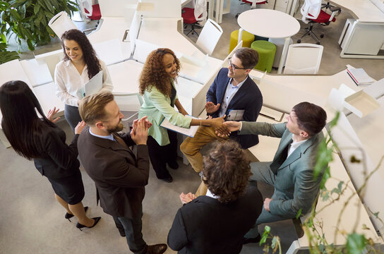 Businesspeople handshake meeting team agreement success. Colleagues in office lead discussion as teammates applaud. Perfect for strategy and partnership. Teamwork and agreement show success.
