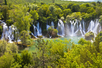 Wide panoramic view of cascading waterfalls in wooded park with waterfall landscape wilderness outdoors environment ©  SobuzForge