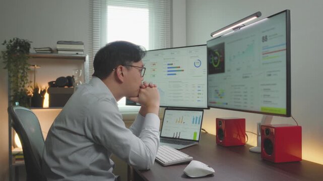 Asian male Financial CEO watching focus database information on screen monitor. Entrepreneur business idea concept.
