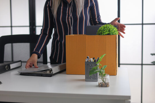 Businesswoman Packing Belongings in Box After Resignation or Layoff.