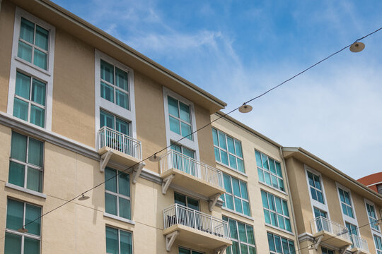 Modern Apartment Building with Balconies and String Lights Under Blue Sky