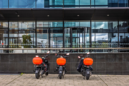 Delivery scooters outside office building, Madrid, Spain