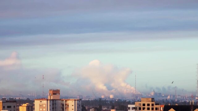 Industrial factory releasing smoke and polluting city air