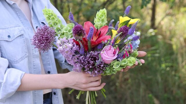 Woman with bouquet of beautiful summer flowers outdoors, closeup