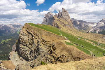 Naklejka premium Seceda mountain ridge with sharp rocky peaks and green grassy slopes in Italian Dolomites under blue sky, scenic alpine summer landscape of Odle Geisler mountains
