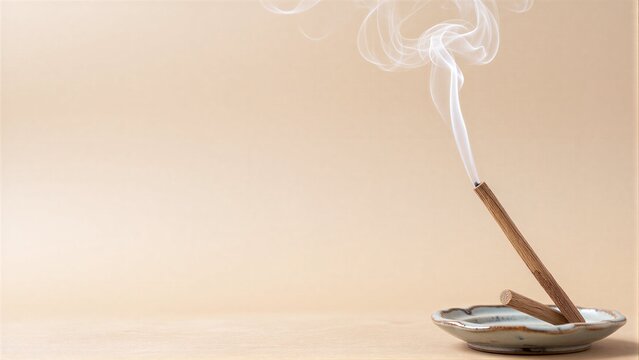 Smoke curls upward from a lit incense stick in a small ceramic holder.