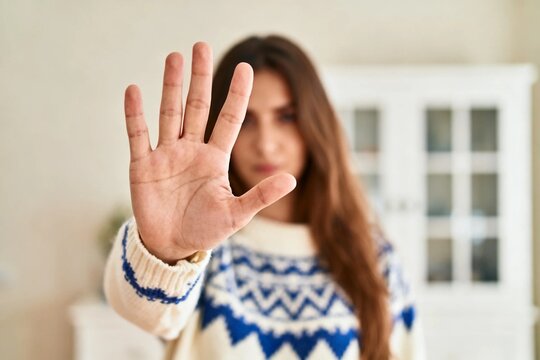 Young woman showing stop gesture indoors