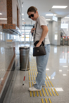A blind woman buys a subway ticket.