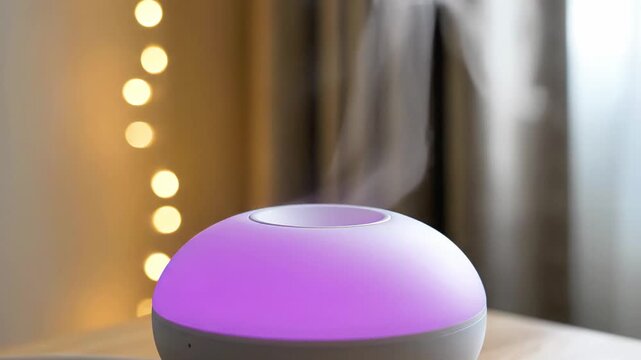 Essential oil diffuser glowing in a dark room.