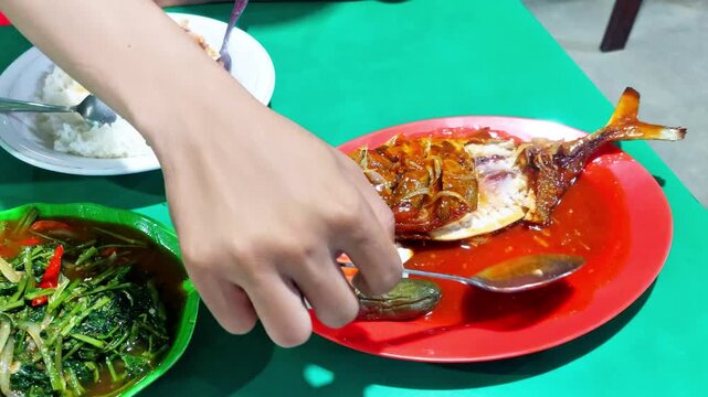 dinner, on the plate there is sea fish with sour and sweet sauce and a plate of stir-fried water spinach, very delicious