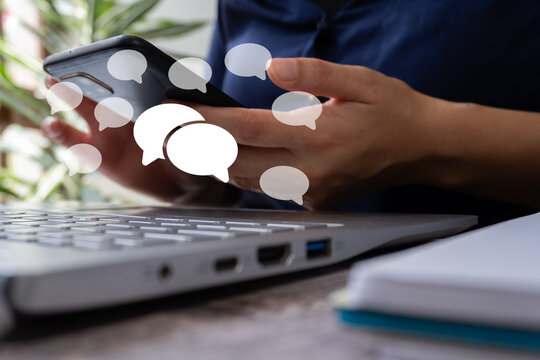 Person uses smartphone with chat icons floating around