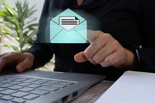 Hand taps digital mail icon on laptop screen