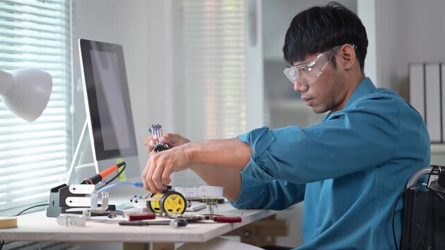 Asian engineer assembling robotics components in office