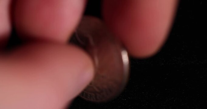 an old  worn quarter dollar coin on black velvet fabric, one old, worn, scratched 25-cent coin in close-up on black velvet, close up