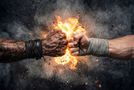Two muddy fists colliding violently creating a bright fiery explosion