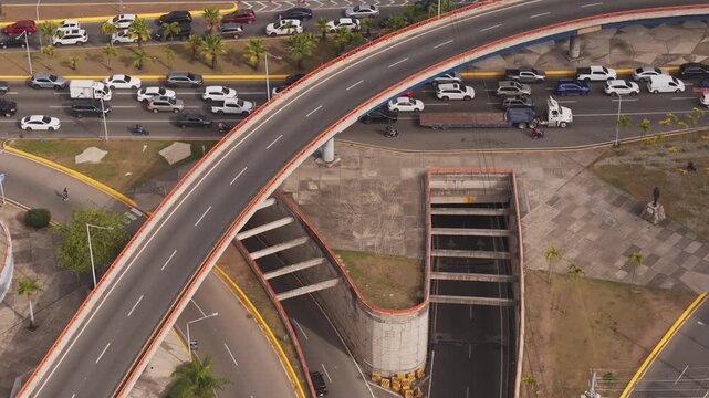 Modern civil engineering concept showing top-down aerial perspective of a curved flyover overpass and underpass tunnel system