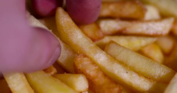 Yellow potato french fries fast food, many greasy french fries chips lying in big heap after cooking in deep fryer machine