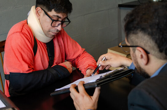 Personal Injury Lawyer Pointing at Claim Document for Injured Client