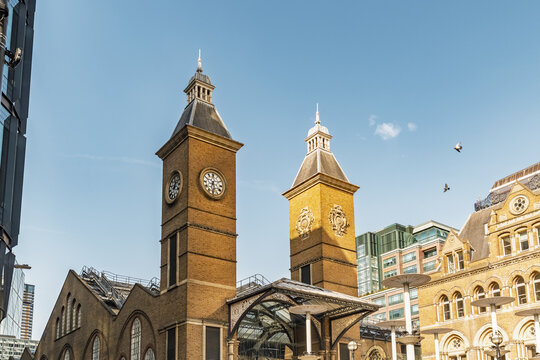 View of the historic clock towers and brick architecture of St Pancras International station under a clear blue sky in London, England, United Kingdom.