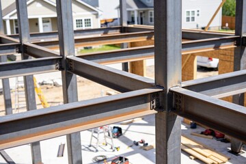 Fototapeta premium A close-up view of structural steel beams being assembled for a residential building construction.