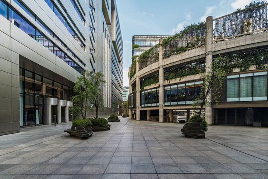 View of Paternoster Square with modern office buildings, glass facades, stone-paved pedestrian plaza, and integrated planters with small trees London, England, United Kingdom.