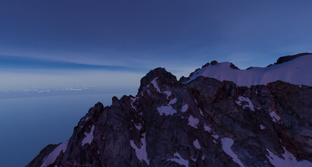 Fototapeta premium Snowy Mountain Ridge at Twilight Over Ocean Horizon With Stars — 3D Rendering