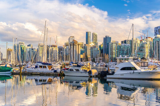 Yachts and downtown skyline reflecting in water at sunset in Vancouver, British Columbia