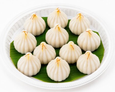 Sweet modak in plate on white background