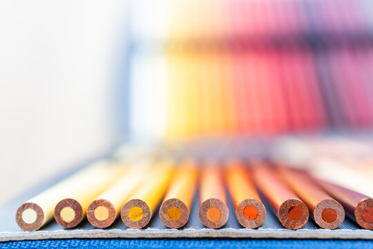 colorful pencils lined up in pencil case with shallow depth of field