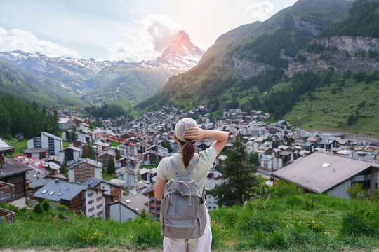Woman Tourist Exploring Zermatt, Switzerland. Happy Traveler Visiting Zermatt Village Viewpoint and Matterhorn, Famous European Landmark, Popular Tourist Attraction and Travel Destination in Europe