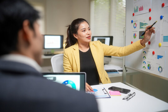 Businesswoman Presenting Financial Charts in Office Meeting