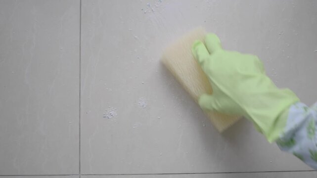 Cleaning a surface with a sponge and gloves