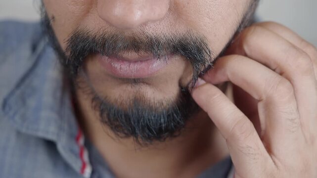 Man touching his beard while thinking