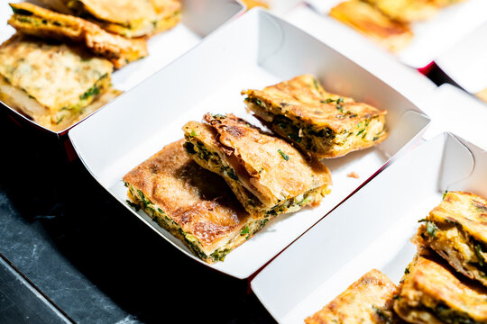 Close-up of Martabak Telor, an Indonesian savory stuffed pancake with egg and meat, served in a paper tray