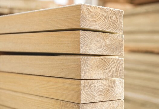 Stacked timber wood boards displaying natural grain, raw texture, and organic patterns, suitable for construction, carpentry, forestry, architecture, backgrounds, materials, and industry.