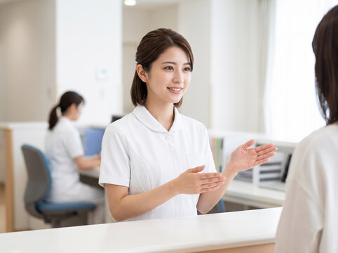 病院の総合案内で親切に応対する医療スタッフの女性