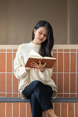 Beautiful Asian woman reading book in outdoor