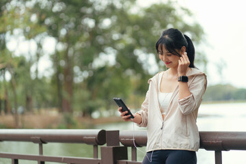 Obraz premium Attractive asian woman listening online music at outdoor.