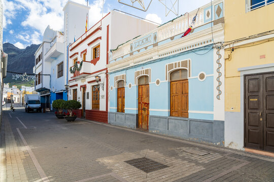 View of the colorful historic buildings in La Aldea de San Nicolas with traditional wooden doors and blue facades along a quiet street in Las Palmas, Canary Islands, Spain.