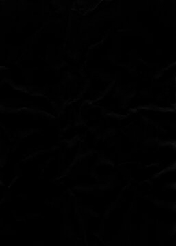 Dark minimal black crumpled paper sheet texture with subtle shadows and gentle wrinkles creating a smooth abstract backdrop for elegant designs.
