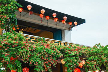 ベトナム・ホイアン旧市街の建物の軒下に咲く花と赤いランタンの風景 © YUSUKE SAKAI