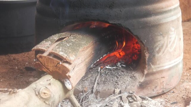 Firewood smolders in a traditional clay oven