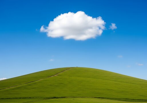 Single fluffy white cloud floating above a vibrant green rolling hill under a clear blue sky
