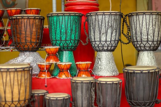 Traditional hand drums and djembe musical instruments in souvenir shop.