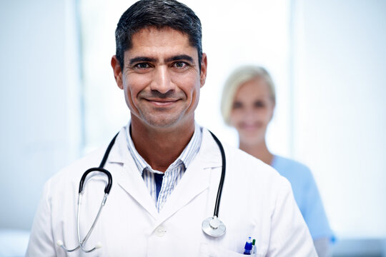 Doctor, happy man and colleague in clinic for medical support, primary healthcare or about us pride. Health portrait, staff leader and smile in hospital for patient care, service integrity and trust