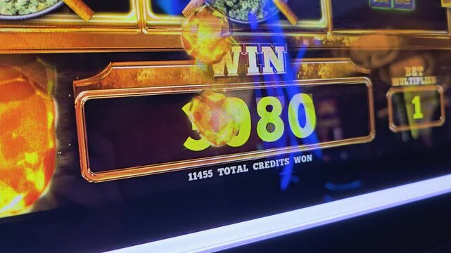 Close-up of casino game credits increasing on a slot machine screen, with glowing gold numbers, neon reflections, bonus graphics, and colorful lights for gambling stock footage.