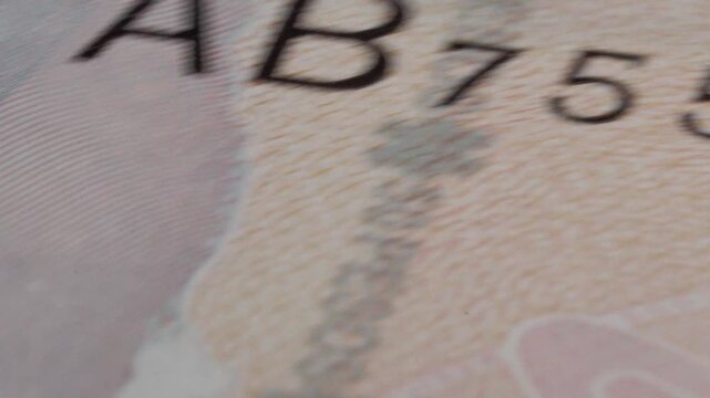 Macro close up of a spinning fifty Mexican peso banknote highlighting printed details, security features and currency design in continuous rotational motion