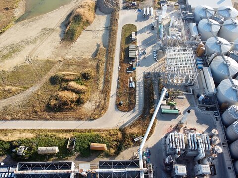 Aerial view of the RenEco industrial facility featuring large storage silos, processing tanks, and surrounding infrastructure in Wymington, England, United Kingdom.