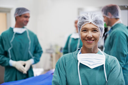 Woman, surgeons and smile with portrait of doctors in ICU for surgery, healthcare or procedure. Happy medical professional, confidence and specialist for theatre, emergency care and team in hospital