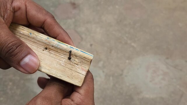 Rotating a bamboo wood piece fitted onto a drill bit tip by hand